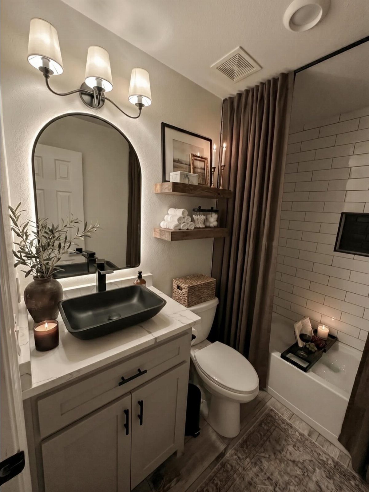 A modern bathroom with a white vanity, black vessel sink, arched mirror, and wooden floating shelves.